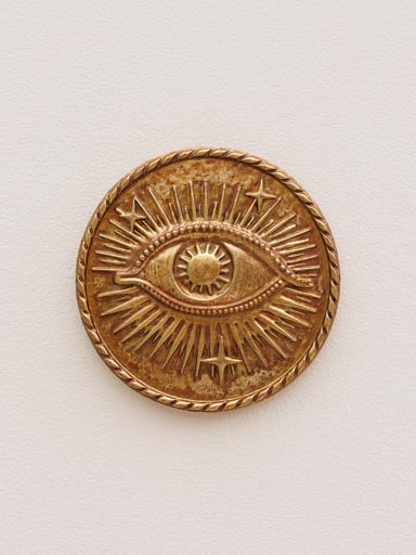 Starry eye on golden wall medallion